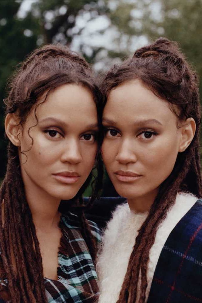 two twins posing together in grassy forest sharing a coat, byredo holiday, fragrance, makeup, perfume 