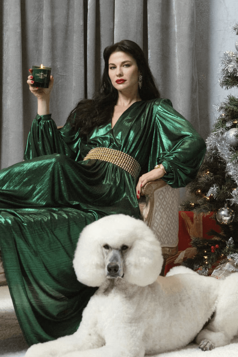 woman posing with candle and poodle by a christmas tree, winter fragrance, beauty